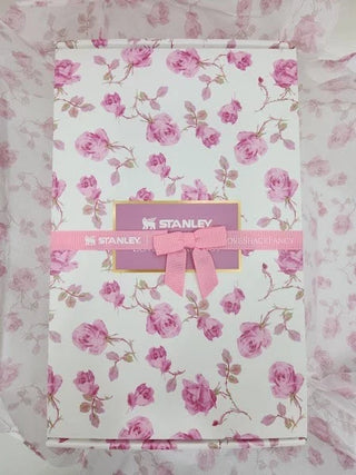 Floral-patterned box with a pink bow and 'Stanley' label on a matching floral background.