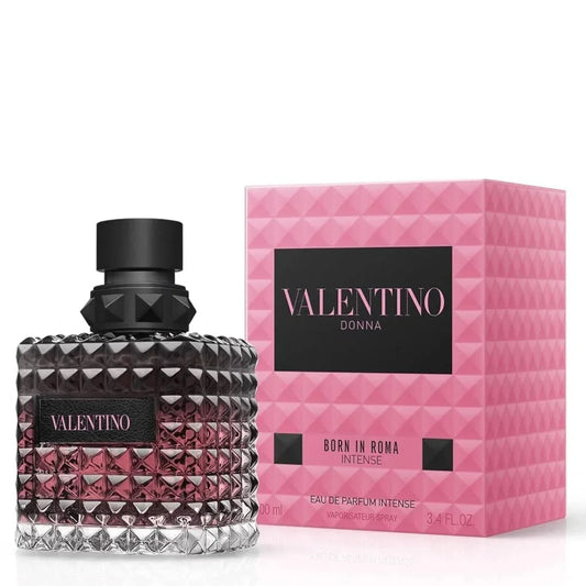 Valentino Donna Born in Roma Intense Eau de Parfum bottle with a textured faceted glass design and black cap, shown next to its pink geometric-patterned box.